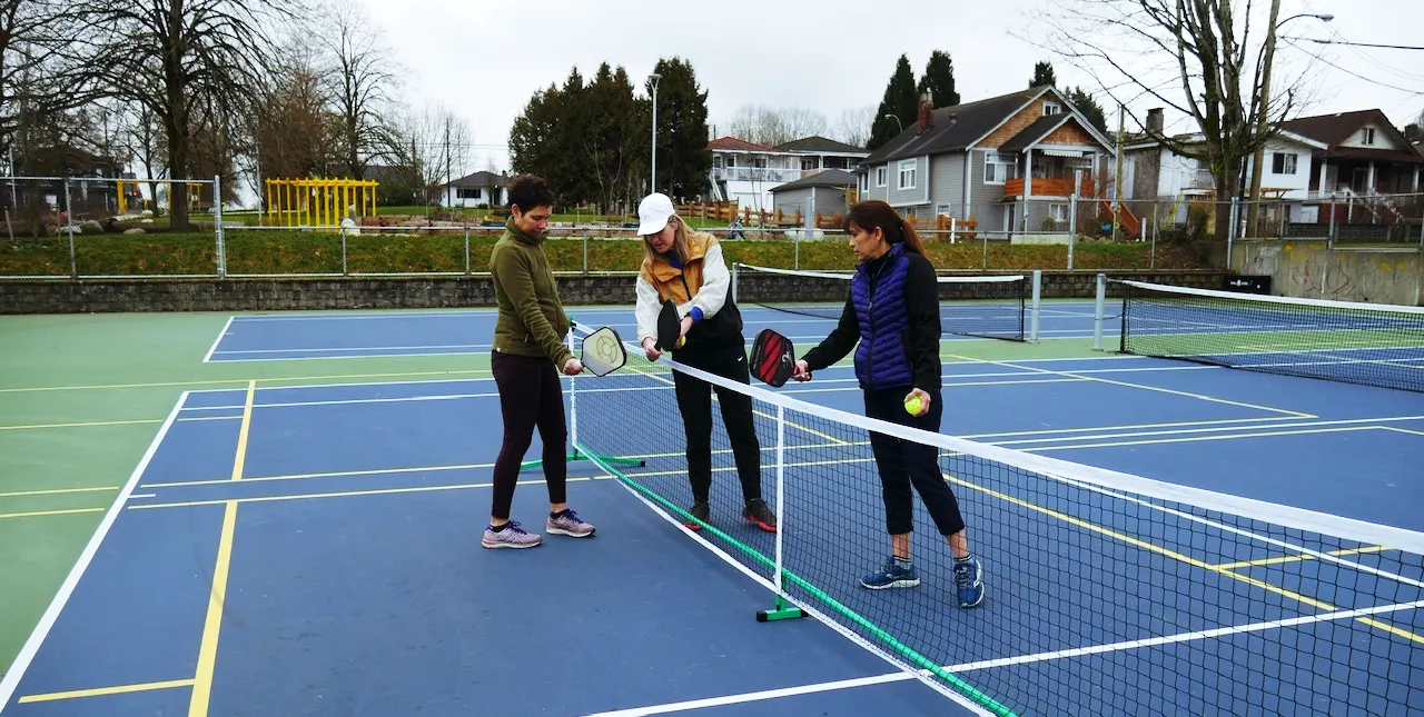 Diane giving two beginner players pickleball coaching in Vancouver, BC
